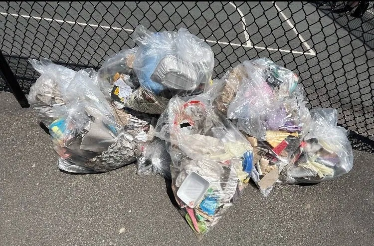 All bags of collected waste piled together at the end of the cleanup
